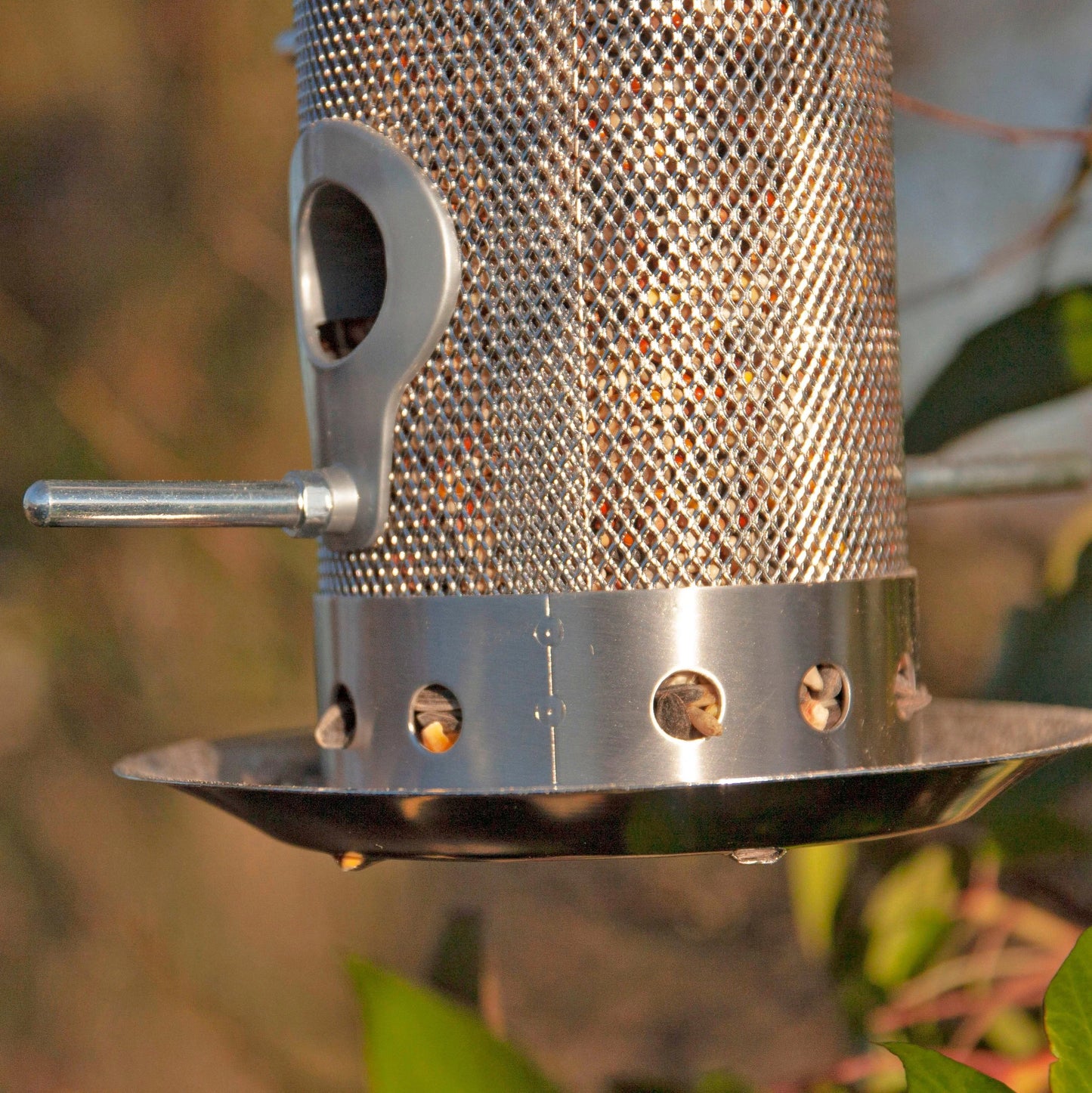 Close up image to show the feeding ports and perches on a stainless steel bird feeder designed to keep seed ventilated.